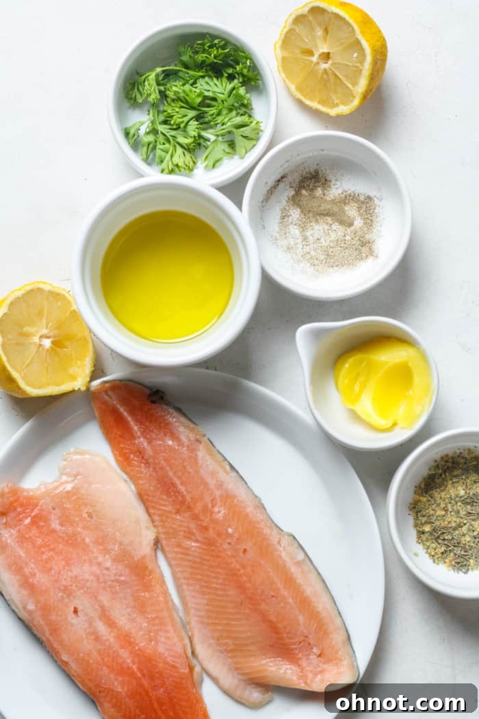 Raw trout fillets alongside fresh garlic, lemon, and herbs, ready for cooking.