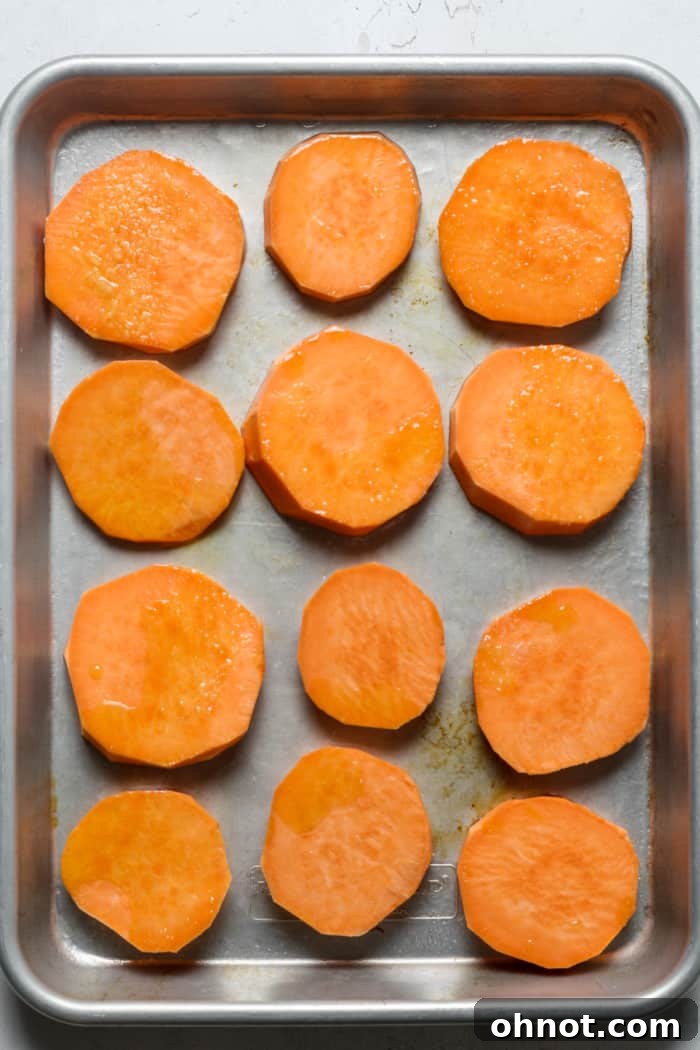Sweet potato slices arranged on a baking sheet.