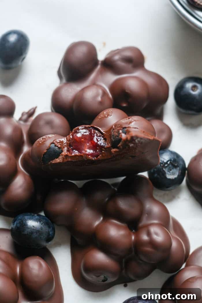 Close-up of a perfectly formed chocolate blueberry cluster, showcasing its crisp coating.