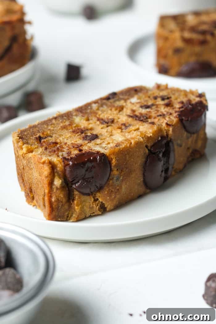 A thick, perfectly cut slice of eggless banana bread, ready to be enjoyed.