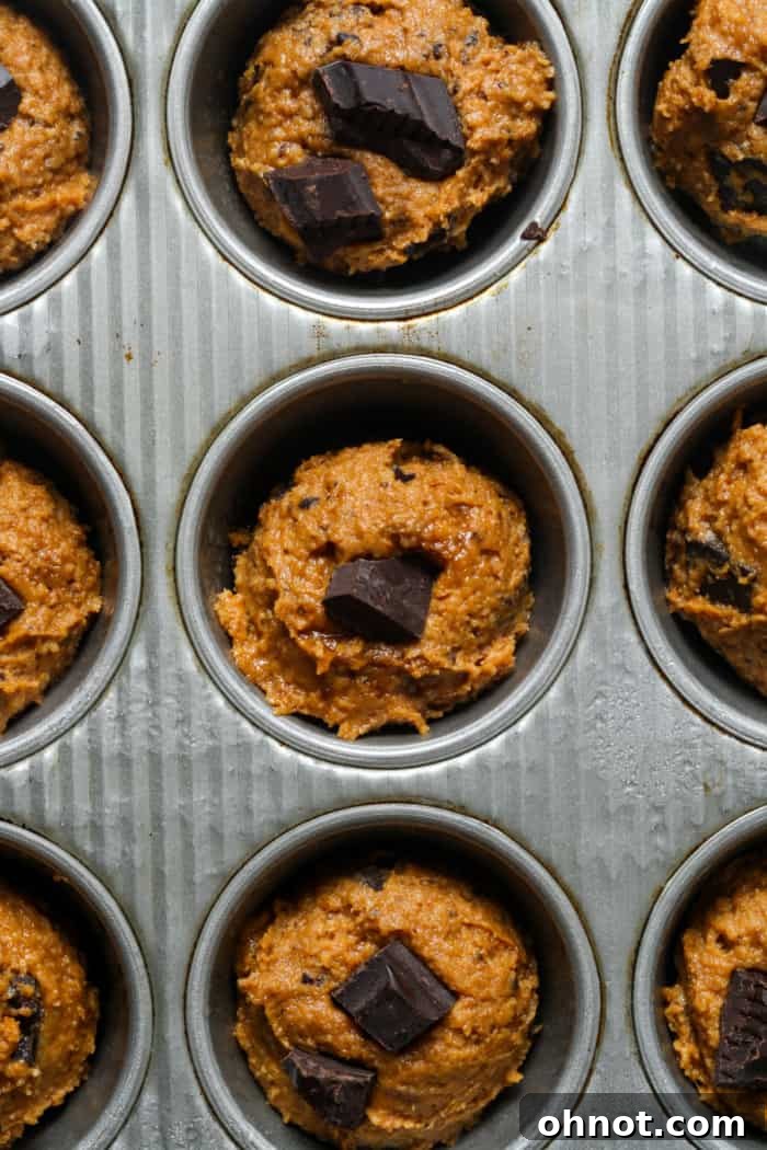 Raw pumpkin muffins in pan.