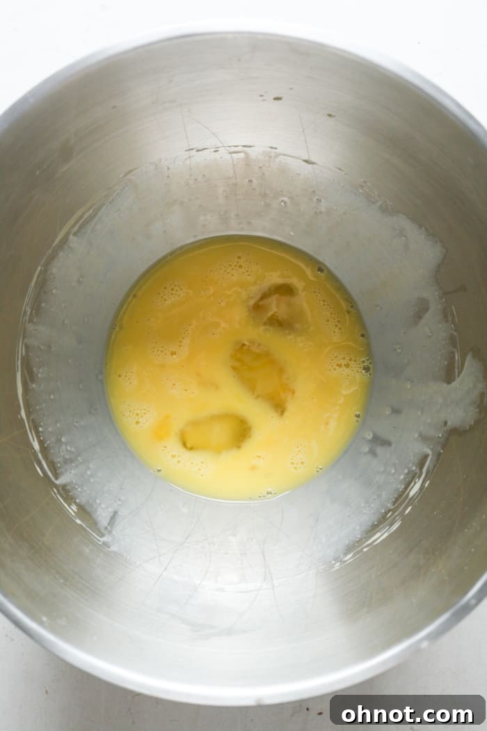 Whisked eggs in a mixing bowl, light and frothy.