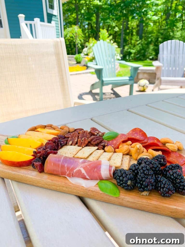 Vibrant red, white, and blue charcuterie board with seasonal fruits, cheeses, and crackers, perfect for a Fourth of July appetizer.