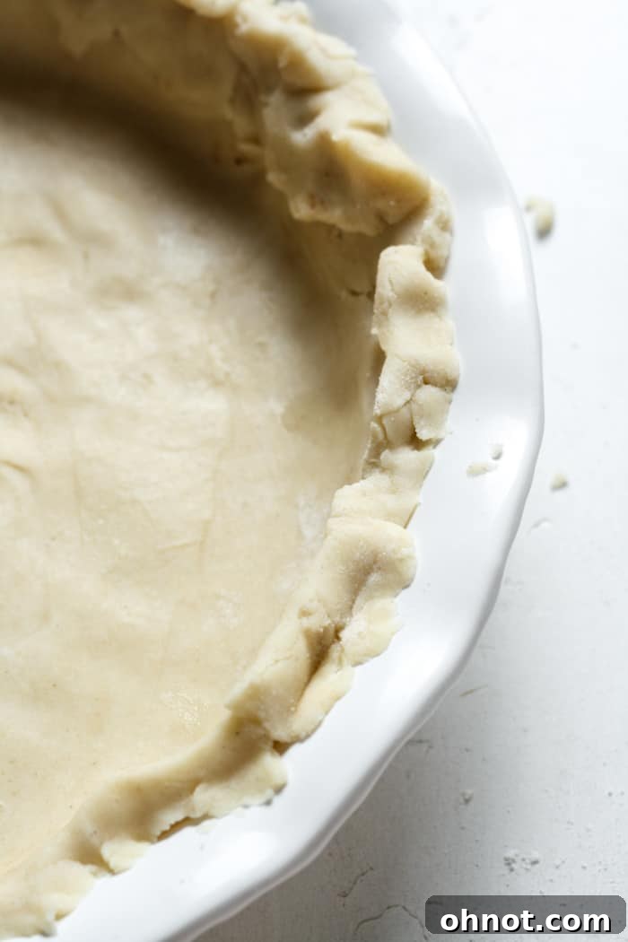 The crimped edges of a par-baked gluten-free pie crust.
