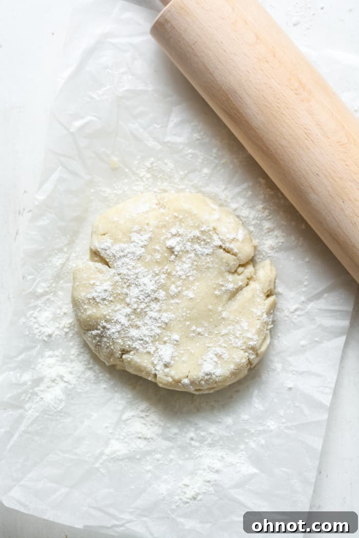 Gluten-free pie dough being rolled out with a rolling pin.