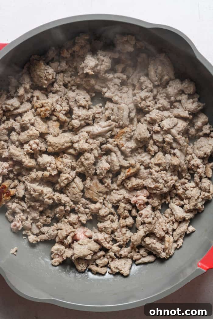 Ground turkey being browned in a skillet, illustrating the first step of preparing the Healthy Hamburger Helper.