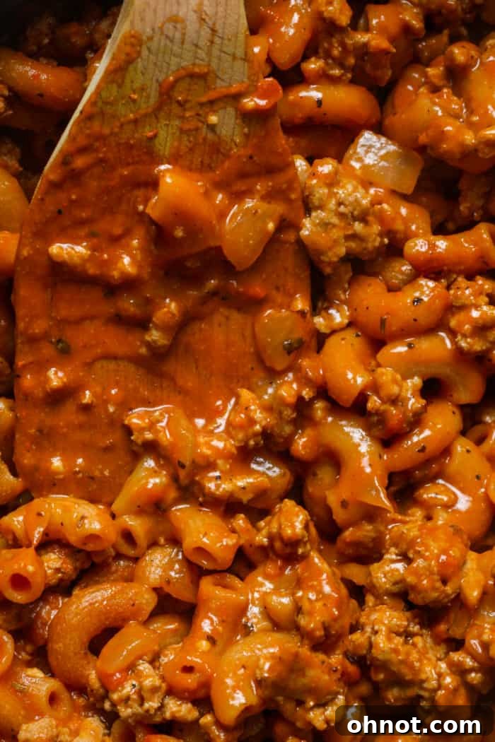 A close-up of warm pasta and meat sauce in a skillet, showcasing the creamy texture and rich color of the Healthy Hamburger Helper.