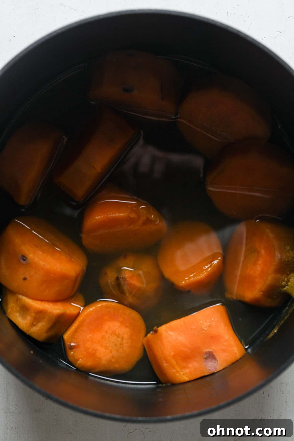 Sweet potatoes boiling in a pot on the stovetop.