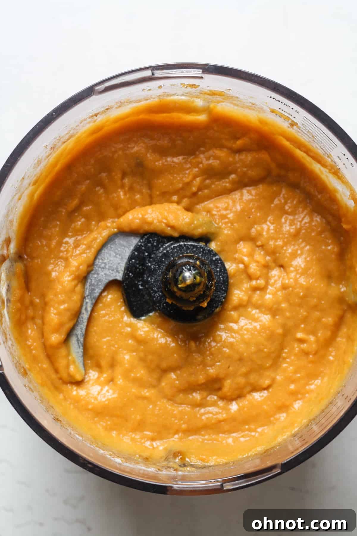 Creamy mashed sweet potatoes blending in a food processor.