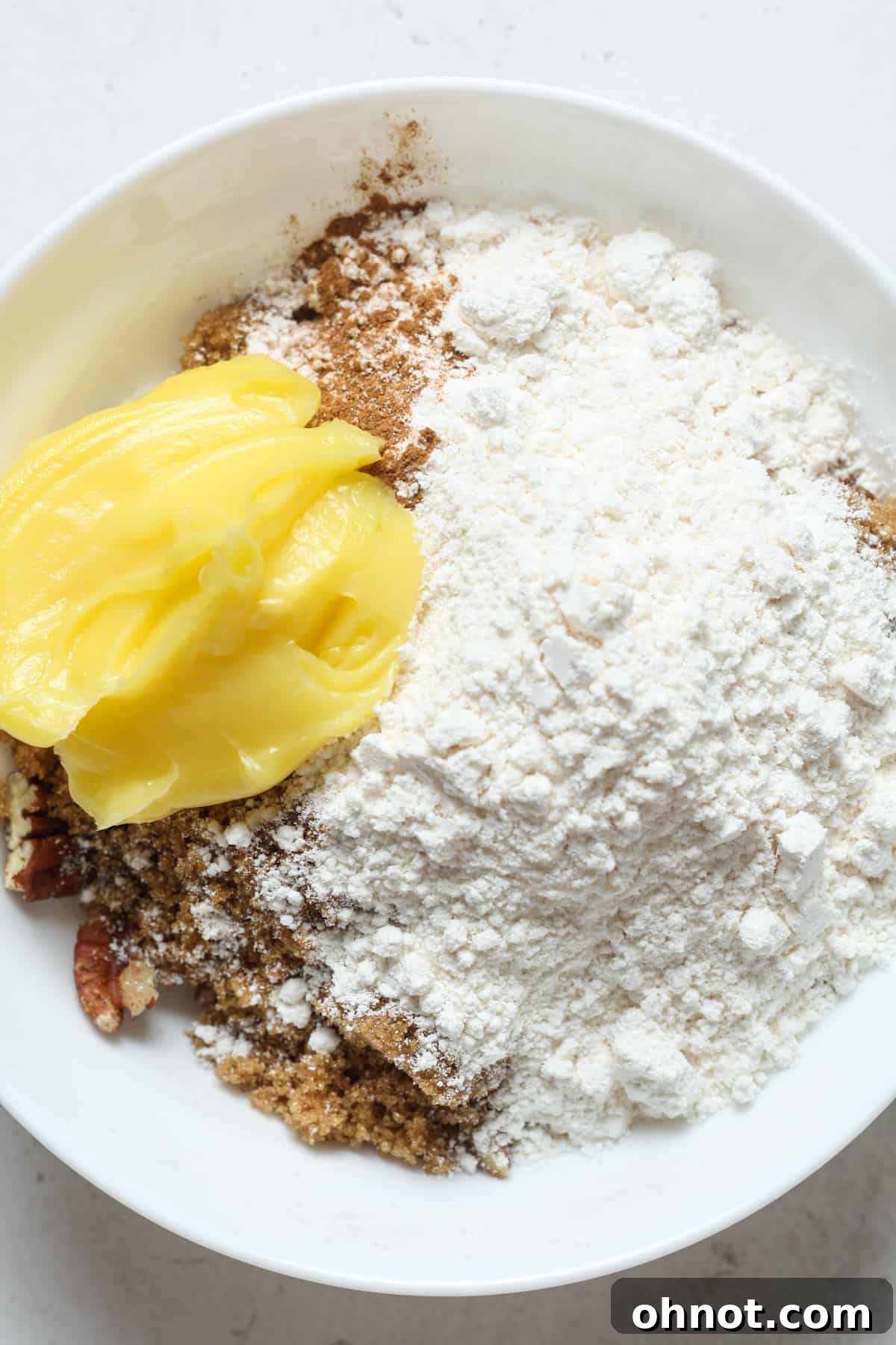 Flour, cold butter, and chopped pecans combined in a bowl for the topping.