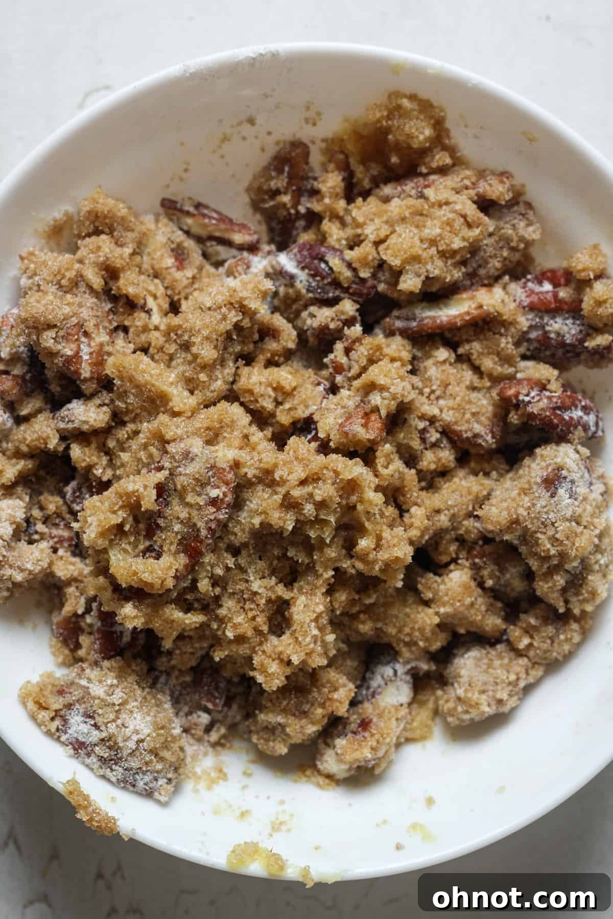 Close-up of the pecan crumble topping mixture, showing its crumbly texture.