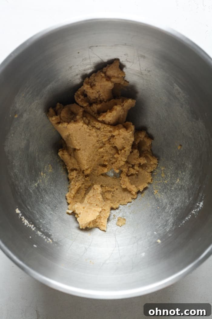 Granulated sugar, brown sugar, and cold butter being creamed together in a stand mixer bowl.