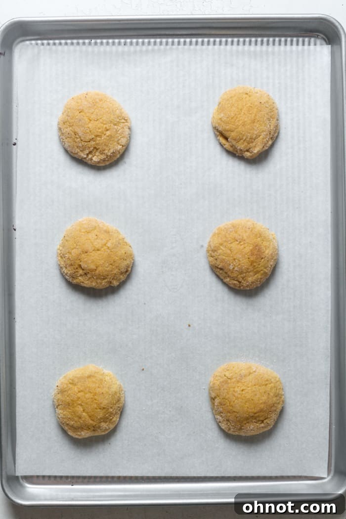Freshly baked pumpkin cinnamon cookies on a baking sheet, slightly golden and soft in the center.