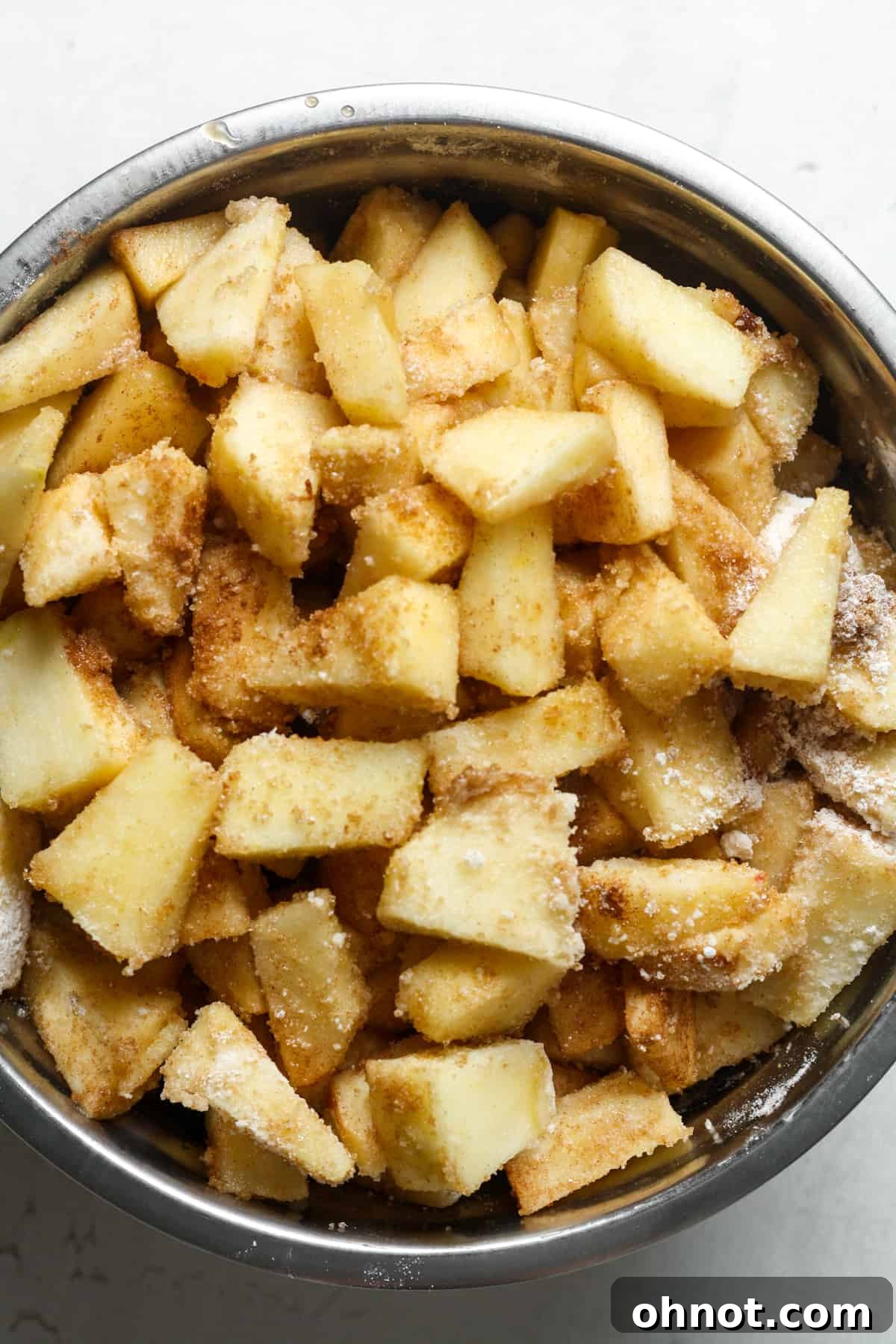 Apple slices fully coated with cinnamon and other spices.