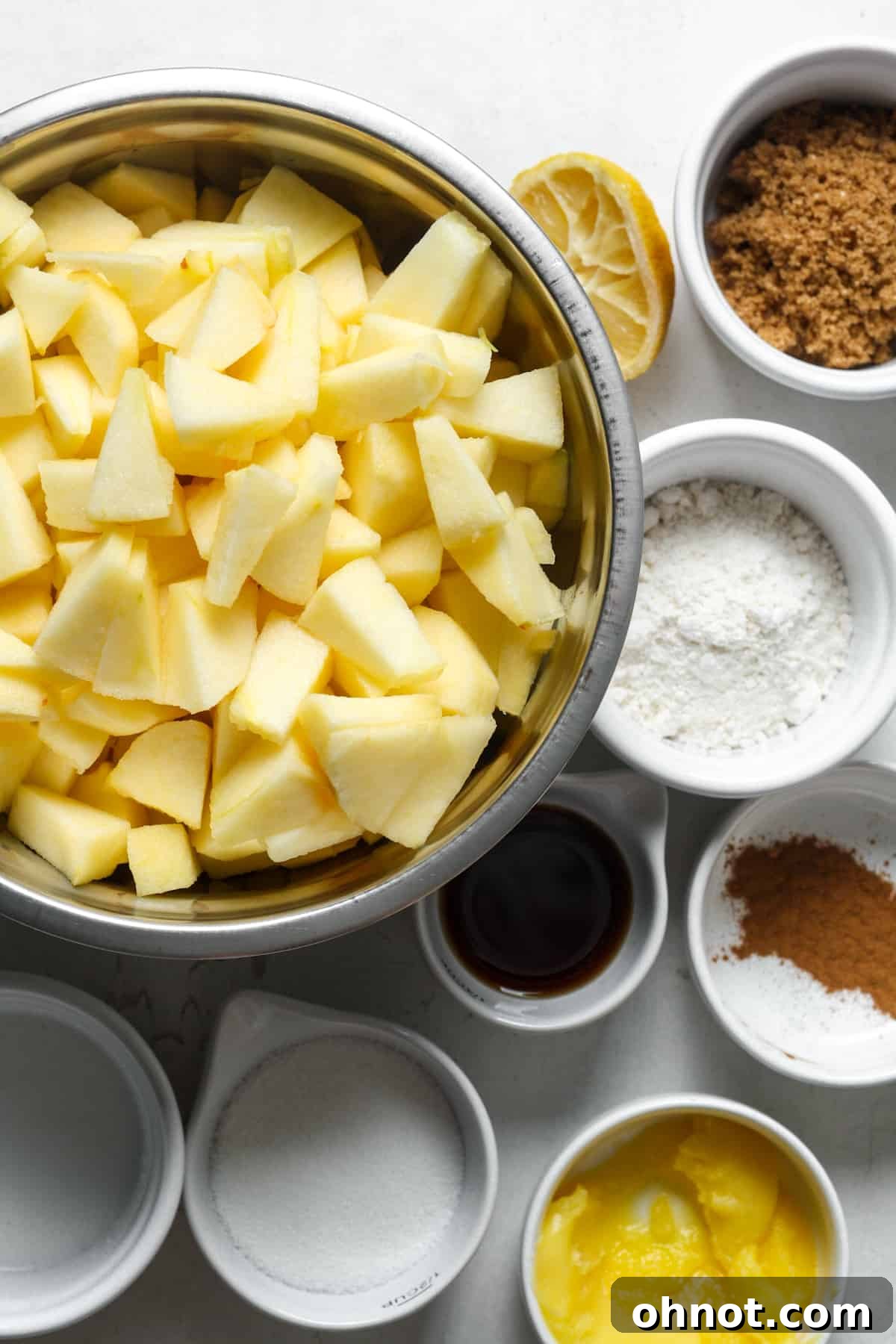 Fresh apples, cinnamon, nutmeg, and other apple pie ingredients.
