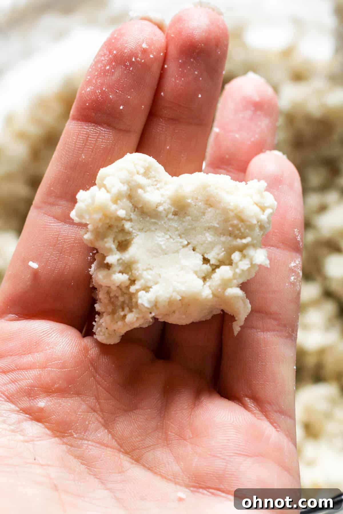 Pie crust dough demonstrating stickiness when pinched.