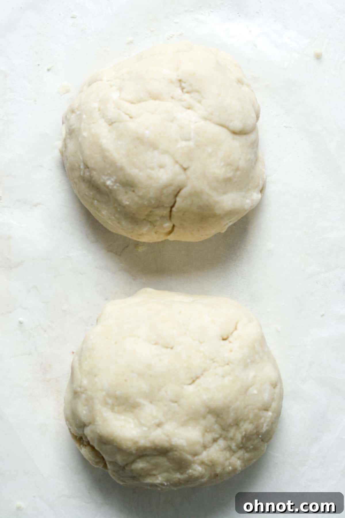 Two neatly formed balls of pie dough.