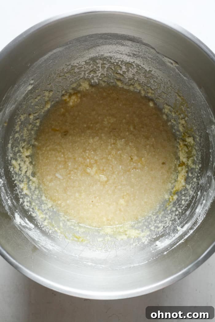 Runny muffin batter with milk, lemon juice, and zest, indicating the wet ingredients have been fully incorporated.