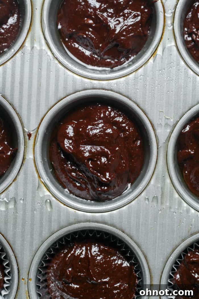 Muffin pan filled with brownie batter, ready for baking.