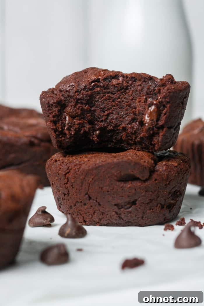 Two freshly baked, fudgy brownie bites stacked, showing their rich texture.