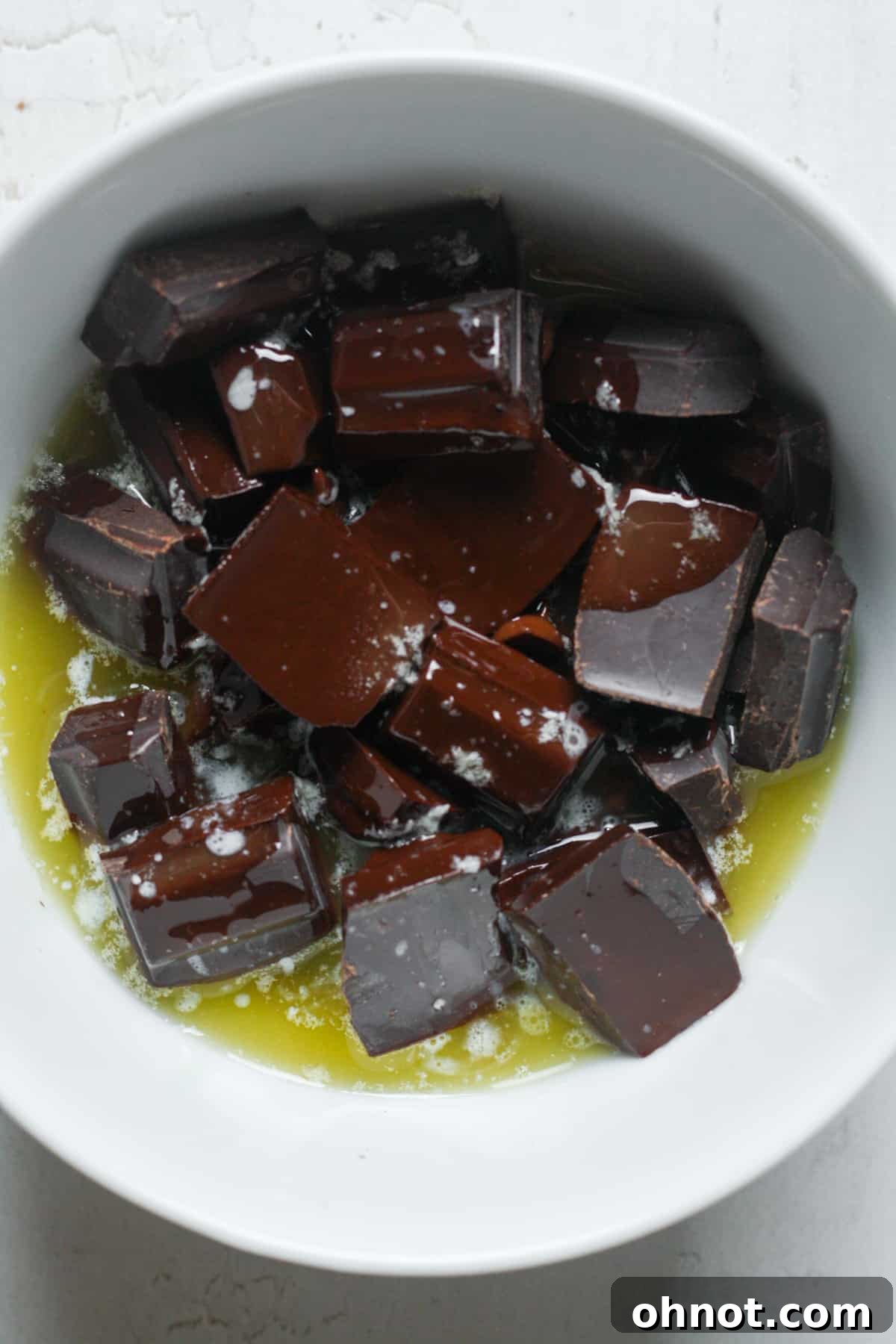 Melted butter and chocolate mixture in a bowl, ready to be stirred.