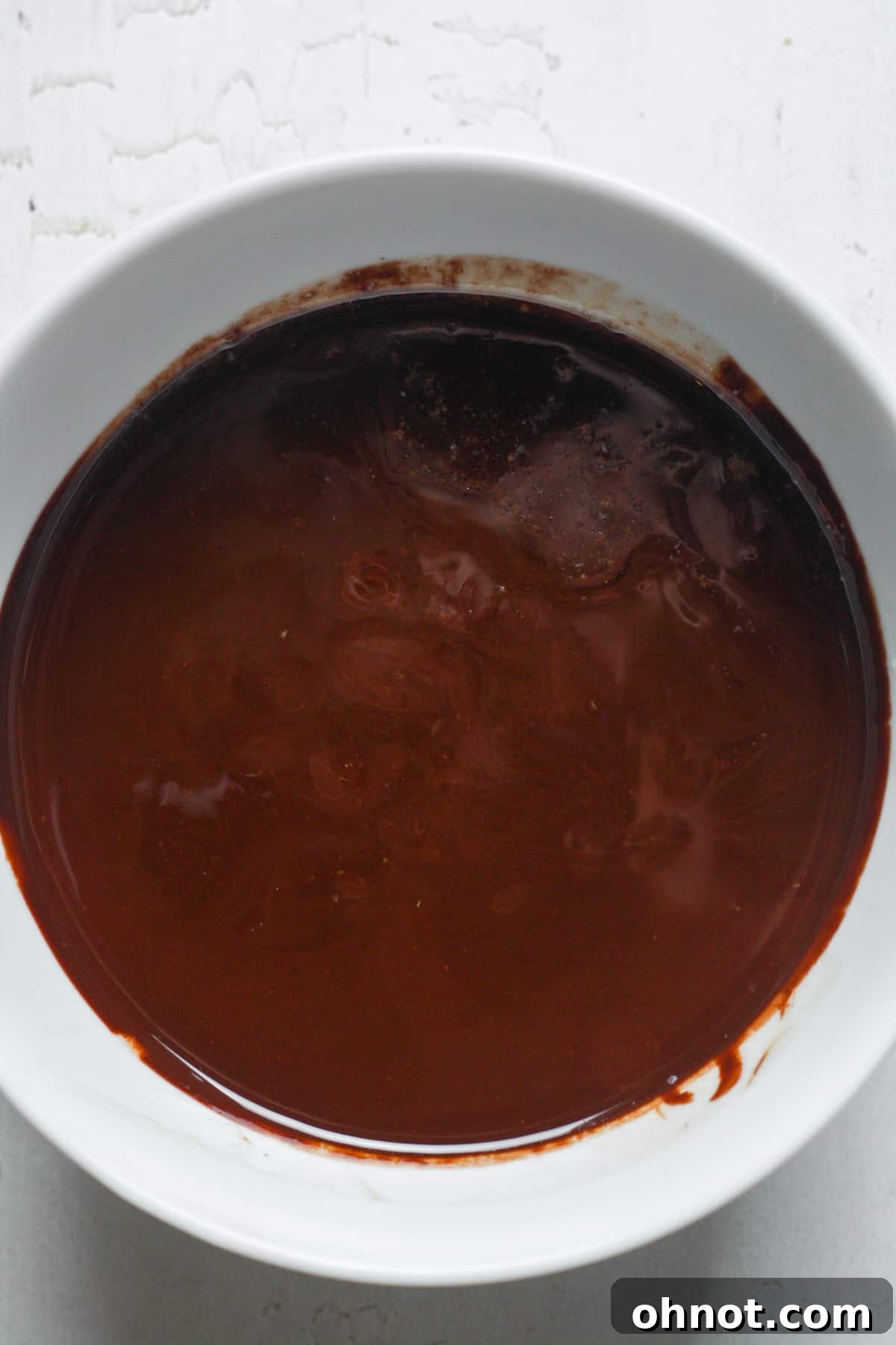 Smooth, glossy melted dark chocolate mixture in a bowl.
