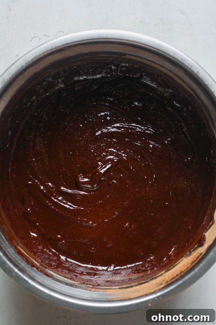 Thick brownie bite batter in a bowl after adding dry ingredients.