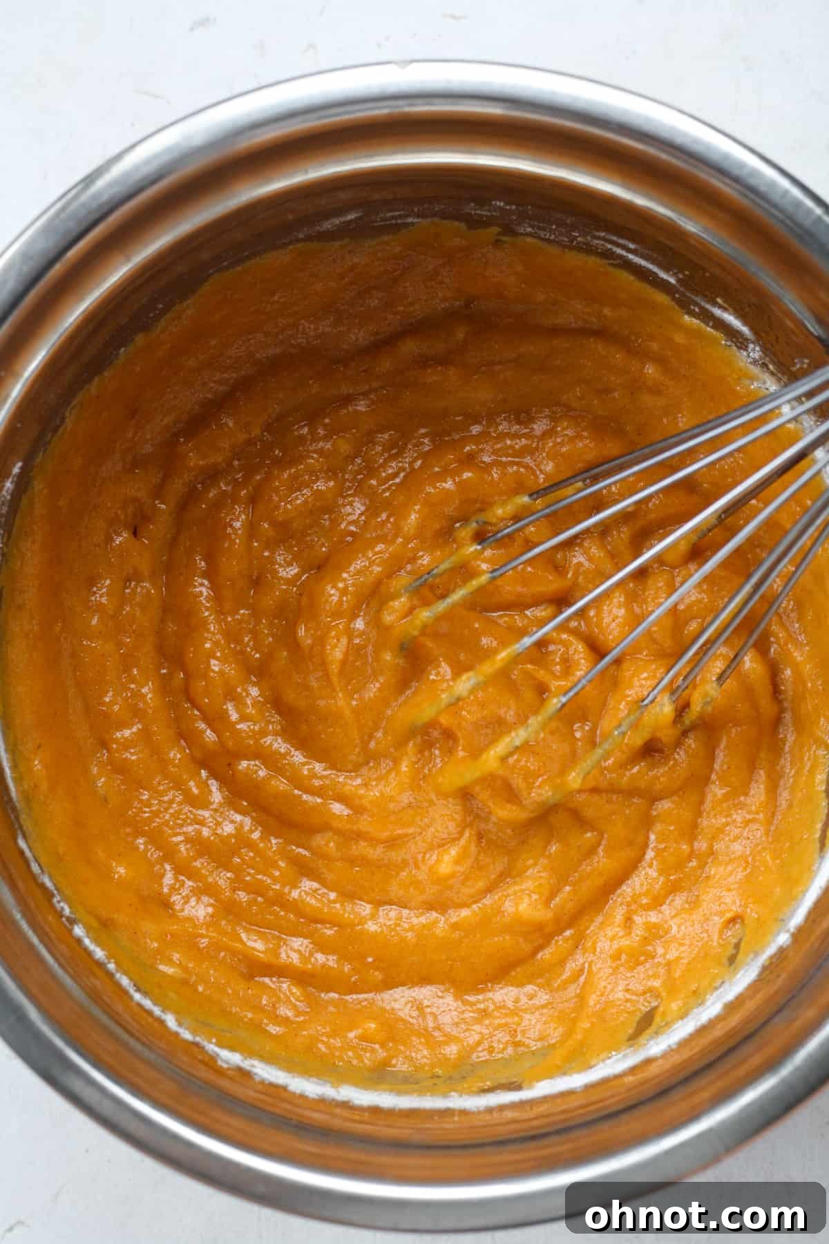 Smooth, orange pumpkin filling batter in a bowl.