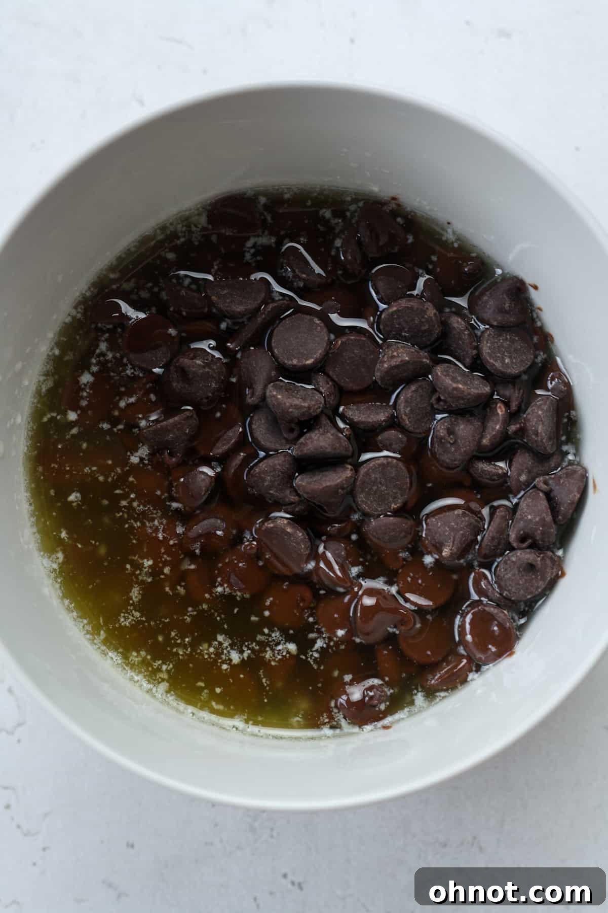 Melted butter and chocolate chips being stirred together.