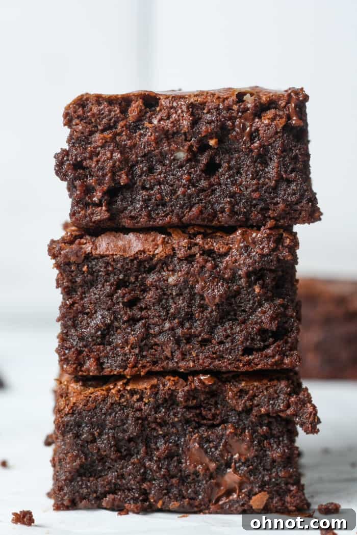 A beautifully arranged stack of three almond flour brownies, showcasing their thick, fudgy texture and delicious appearance, ready to be enjoyed.