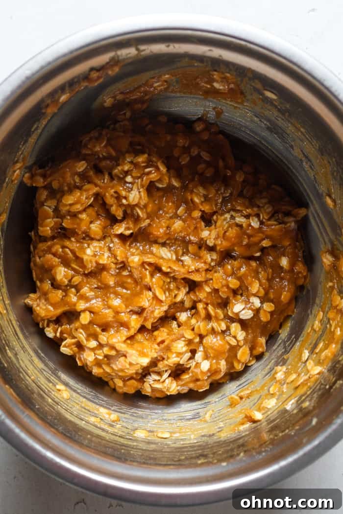 Oats and nut butter being combined in a mixing bowl.