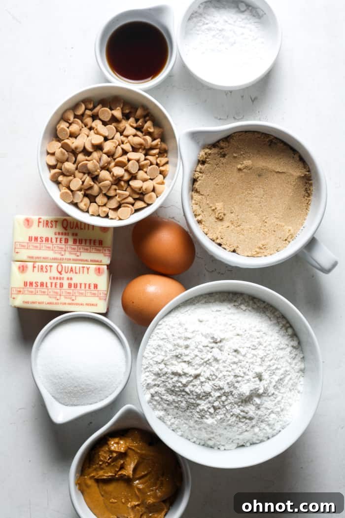 Fresh ingredients laid out for making peanut butter cookies, including butter, eggs, and a jar of peanut butter.