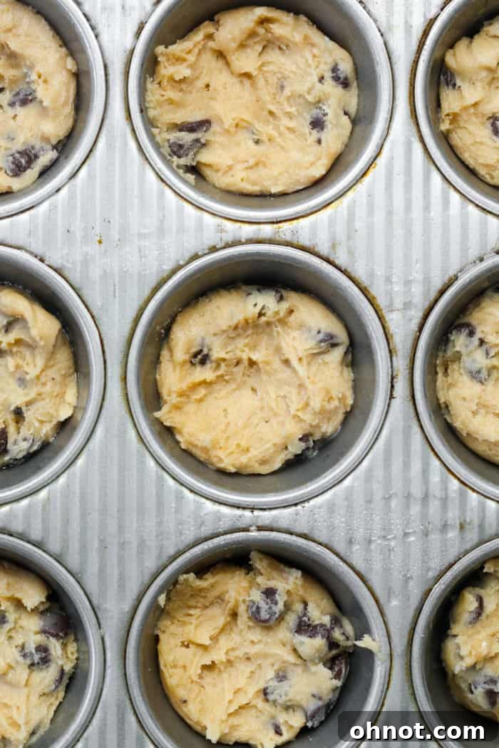 Muffin pan with shaped cookie dough, forming cups.