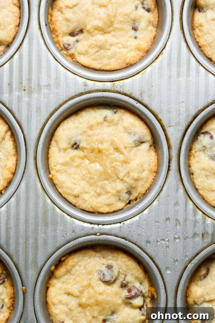Muffin pan with baked cookie cups, golden on the edges.