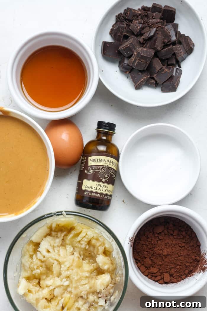 Ingredients for healthy banana brownies laid out: ripe bananas, cocoa powder, peanut butter, and chocolate chips.