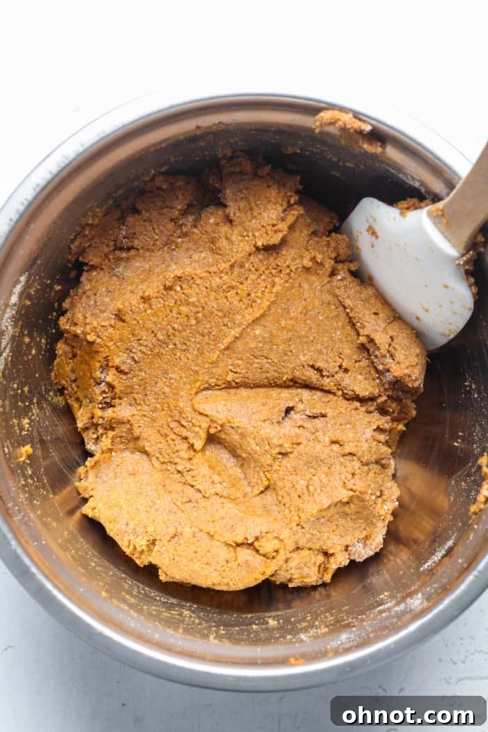 Thick, combined pumpkin bread batter in a mixing bowl.