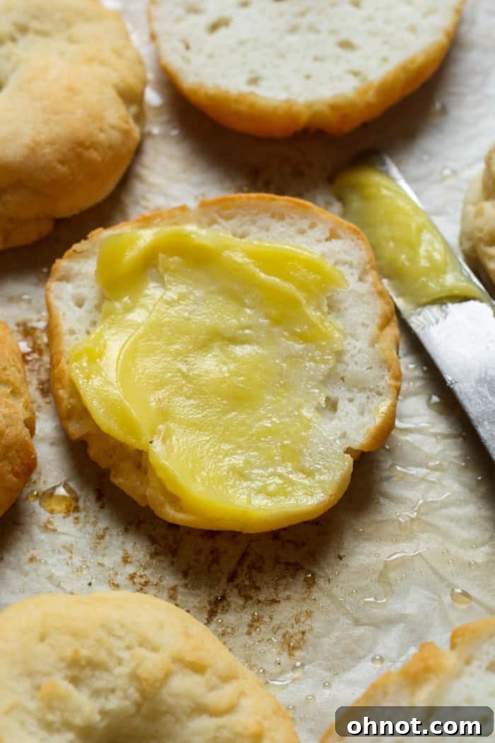 A freshly toasted gluten-free bagel spread with butter, ready to eat.