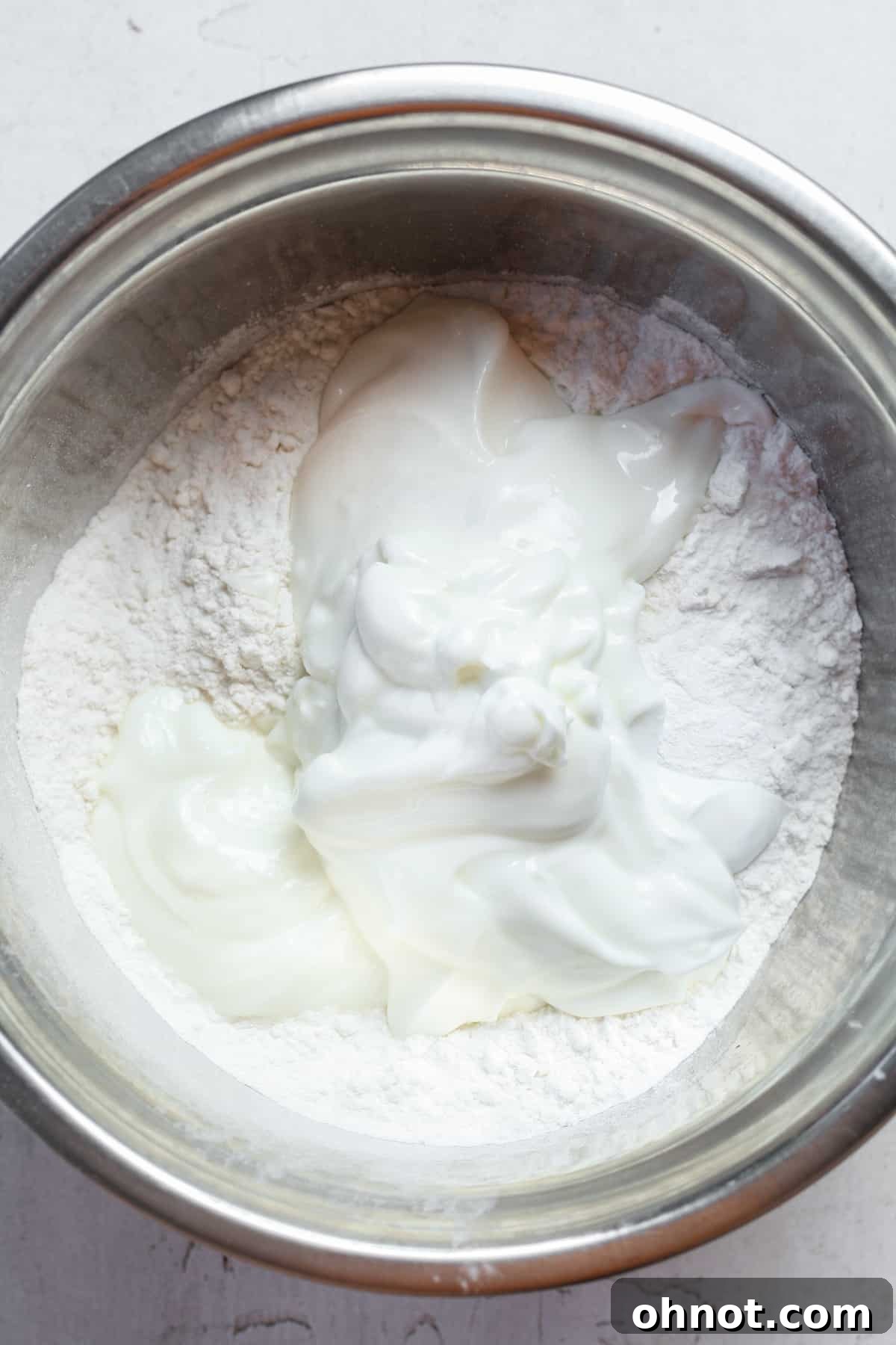 Greek yogurt and gluten-free flour being mixed in a bowl.