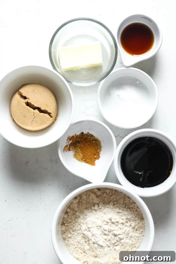 Various gingerbread cookie ingredients, including molasses and spices, laid out on a table.