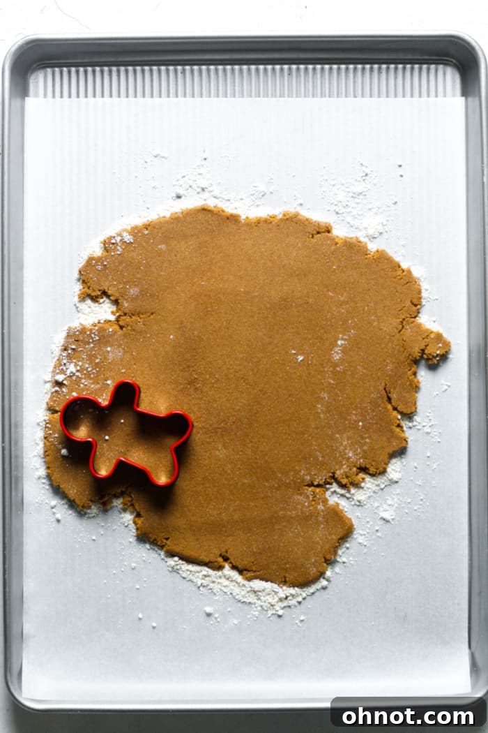 Vegan gingerbread dough rolled out and cut into festive shapes.