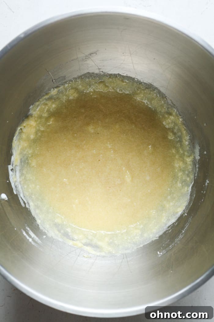 Gooey, creamy batter in a mixing bowl after adding sour cream, egg, and vanilla.