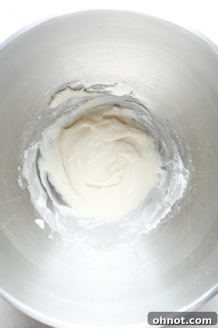 Smooth, creamy homemade buttercream frosting in a stand mixer bowl.