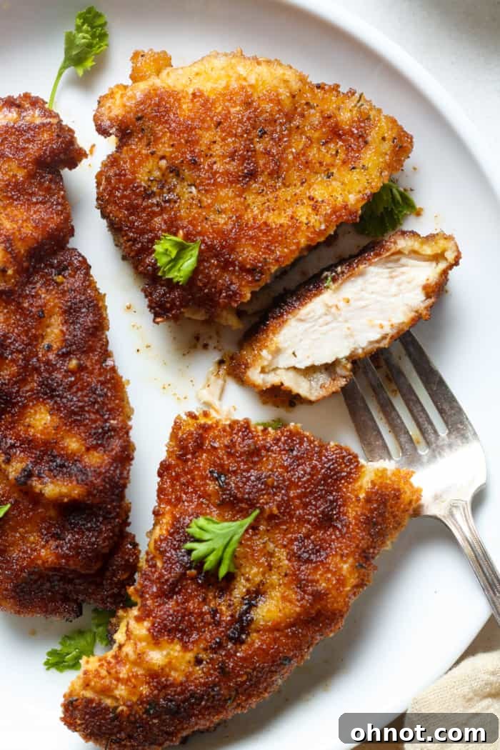 Crispy, golden chicken schnitzel on a plate, ready to be served.