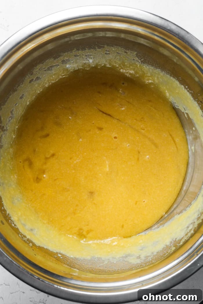 Melted coconut oil, butter, and sugar alternatives being whisked together in a bowl.