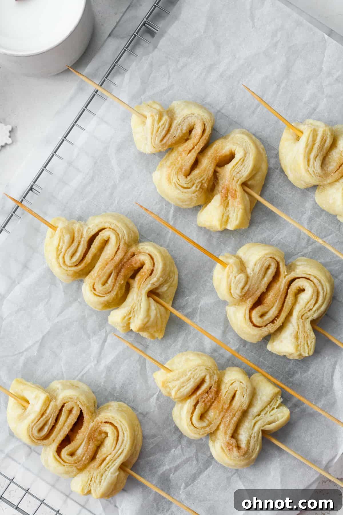 Baked puff pastry Christmas trees, golden and puffy, resting on a baking sheet.