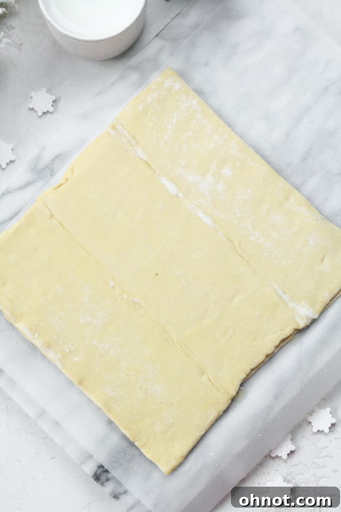 Two sheets of puff pastry layered one on top of the other, forming a single pastry block.