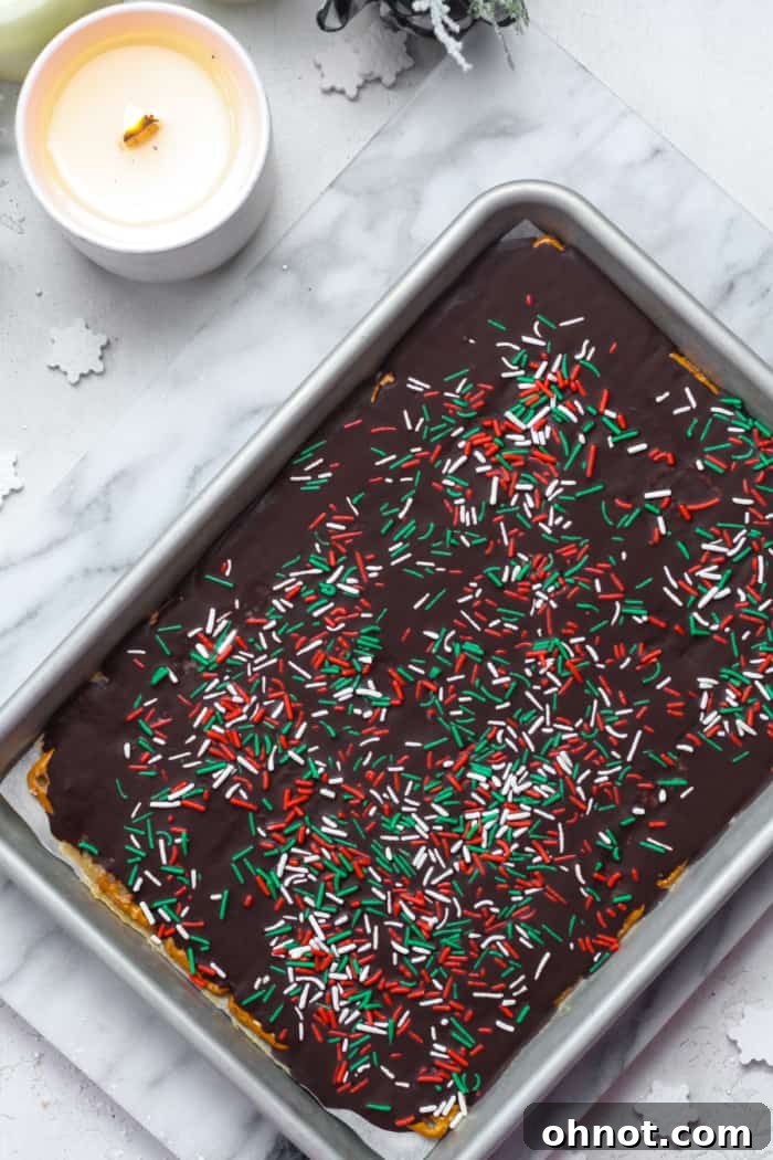 Pretzel crack with melted chocolate and sprinkles chilling in a baking pan.