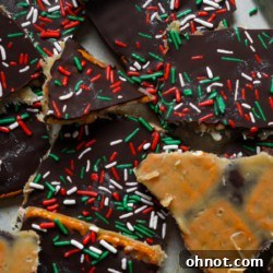 Pretzel crack bark with sprinkles on a festive background.