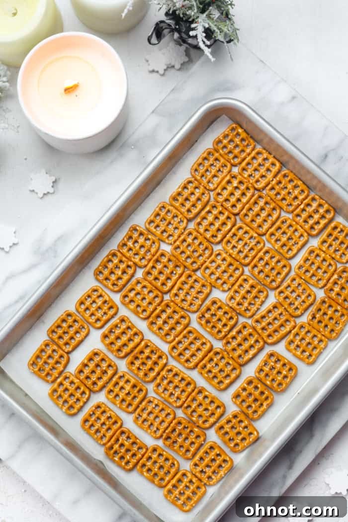 Pretzels arranged in a single, even layer on a parchment-lined baking pan.