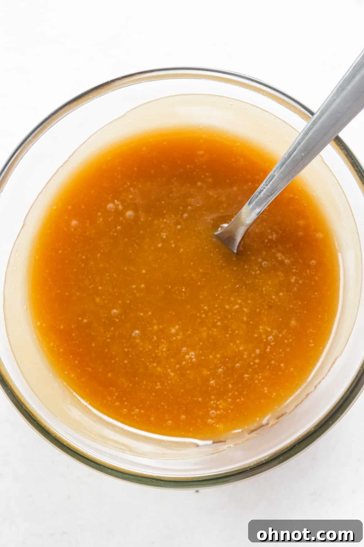Homemade golden brown caramel sauce simmering in a saucepan.